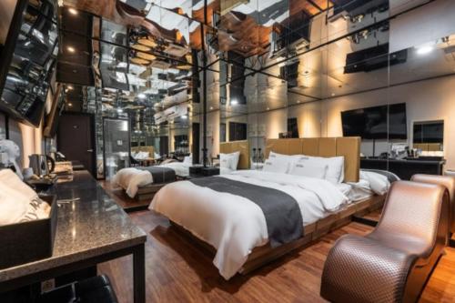 um quarto amplo com 2 camas, uma mesa e cadeiras em You&Me Hotel em Seongnam