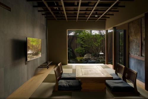 Un comedor con mesa y sillas y una ventana. en Zen Machiya Inn, en Kioto