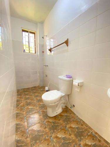 a bathroom with a toilet and a tile floor at Silent Palms Villa in Galu