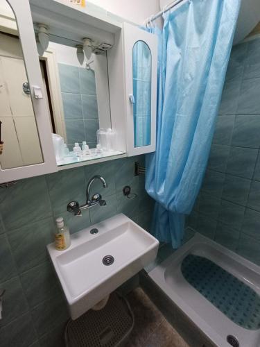 a bathroom with a sink and a mirror at Apartman Borsalino Subotica in Subotica