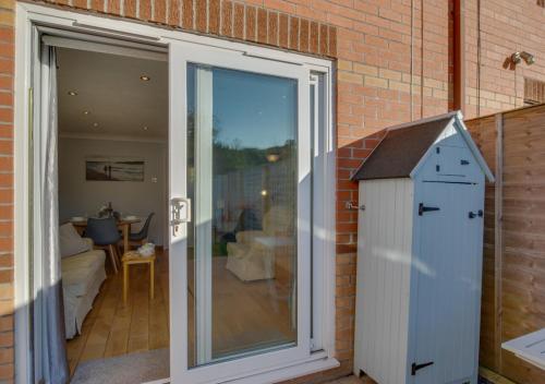 a sliding glass door with a bird house next to it at Tegeirian in Porthcawl