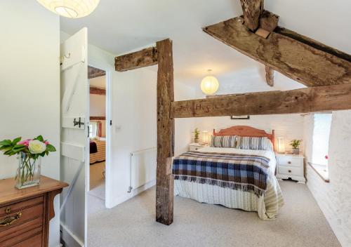 a bedroom with a bed and wooden beams at The Granary in Rhayader