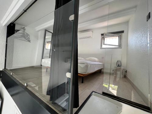 une chambre avec une porte en verre menant à une chambre dans l'établissement Helio 78, au Cap d'Agde