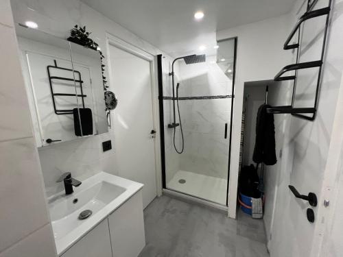 une salle de bain blanche avec une douche et un lavabo dans l'établissement Helio 78, au Cap d'Agde