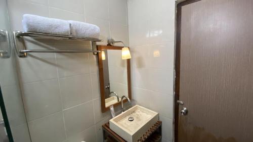 a bathroom with a sink and a mirror at Mawar Asri Hotel in Yogyakarta