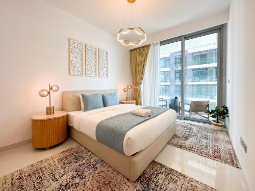 a bedroom with a large bed and a large window at Brand New 2BR Apt with Palm Views and Private Beach - High Floor in Dubai