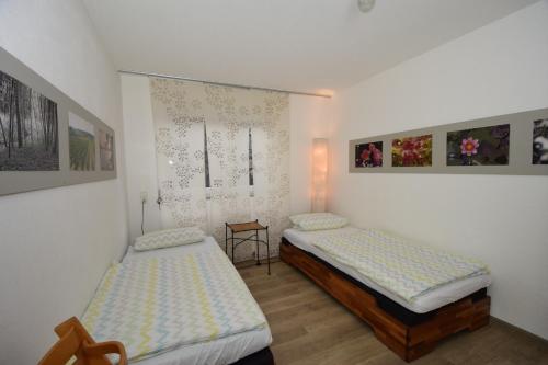 dwa łóżka w pokoju z obrazami na ścianie w obiekcie Ferienwohnung am Obstgarten w mieście Salem