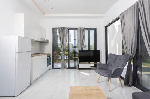 a kitchen and living room with a television and a chair at Lux et Mare in Pefkochori