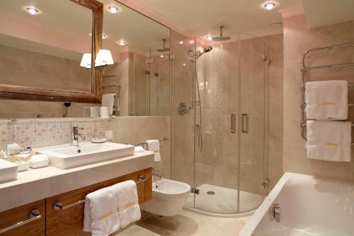 a bathroom with a shower and a toilet and a sink at Sporthotel Lorünser in Zürs am Arlberg