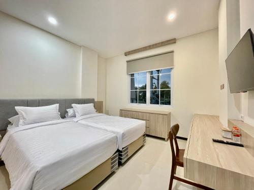 a bedroom with a bed and a desk and a window at Kawa Living in Krukah