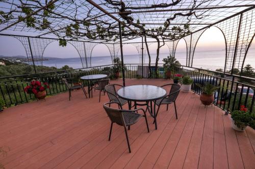 a patio with tables and chairs on a deck at Hotel Panorama in Kalamata