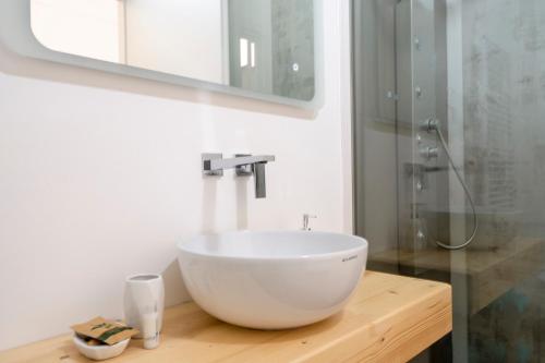 a bathroom with a white bowl sink on a wooden counter at Casa Del Barone - Luxury Suites in Monopoli