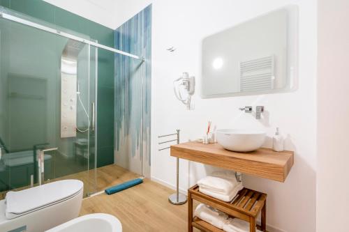 ein Bad mit einem Waschbecken und einer Glasdusche in der Unterkunft Casa Del Barone - Luxury Suites in Monopoli