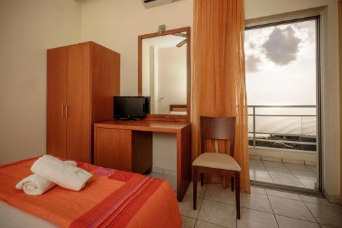 a bedroom with a bed and a desk and a mirror at Hotel Panorama in Kalamata