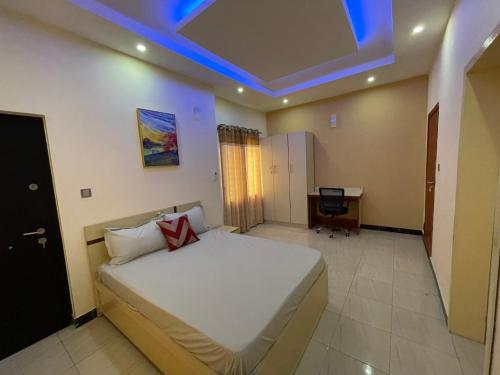 a bedroom with a bed and a desk in it at Lovadek Spacious Apartment in Lagos
