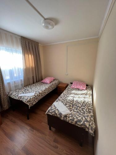 a room with two beds and a window at 4-местные домики in Balqash
