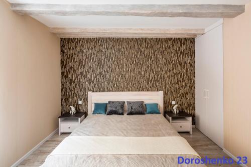 リヴィウにあるDo Lvova Central Apartmentsのベッドルーム1室(大型ベッド1台、ナイトスタンド2台付)
