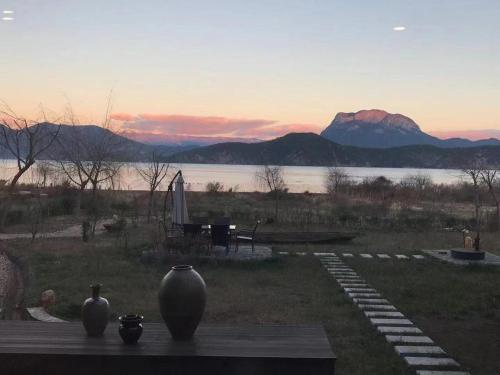 two vases sitting on a table with a view of a lake at Slow Living Villa in Ninglang