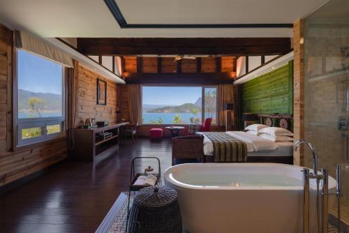 a bathroom with a tub and a bedroom with a bed at Slow Living Villa in Ninglang