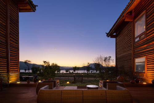a patio with a table and chairs in front of a house at Slow Living Villa in Ninglang
