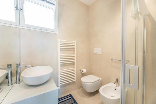 a white bathroom with a toilet and a sink at Marinaia Gran Vista Mare in Marittima