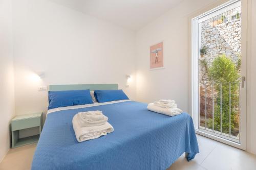 a bedroom with a blue bed with towels on it at Marinaia Gran Vista Mare in Marittima