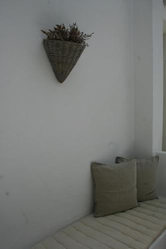 a white room with a couch with a basket on the wall at Korali Hotel in Antiparos Town