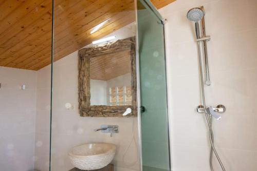 een badkamer met een douche, een wastafel en een spiegel bij Can Mirabell in Calders