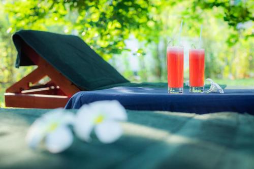 two glasses of red drinks sitting on a table at Sath Villa Naadi Ayurveda Resort in Moragalla