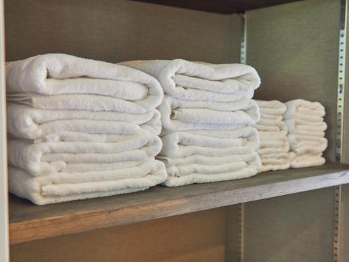 a bunch of white towels sitting on a shelf at ルクス箱根湯本 LUX HAKONE YUMOTO in Hakone