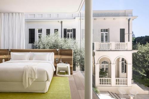 a bedroom with a bed and a balcony at R48 Hotel and Garden in Tel Aviv