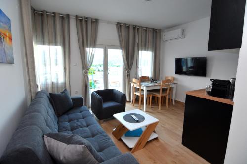 a living room with a blue couch and a table at Blue Lagoon 3 in Kavala