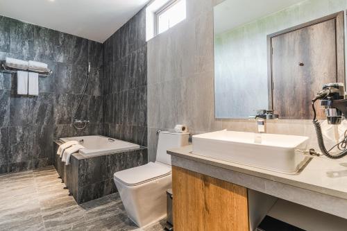 a bathroom with a sink and a toilet and a tub at Sea Breeze Hotel & Villa in Sihanoukville
