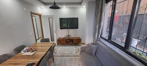 uma sala de estar com uma mesa de madeira e uma televisão em Sam home em Beylikdüzü