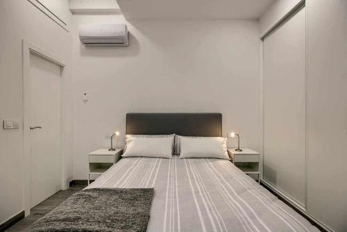 een slaapkamer met een groot bed met 2 nachtkastjes bij RiNa MADRID apartamento 2 in Madrid