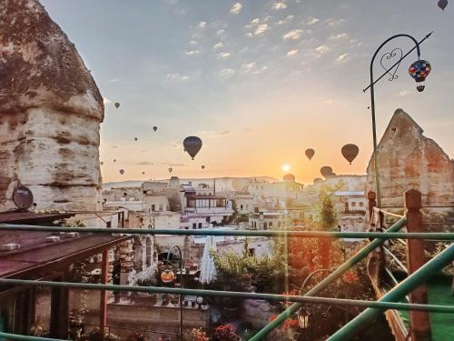 een uitzicht op een stad met heteluchtballonnen in de lucht bij Vintage Cave House Hotel in Goreme