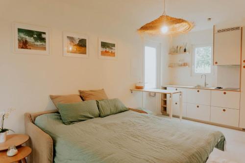 a small bedroom with a bed and a kitchen at Studio Palmito in Bidart