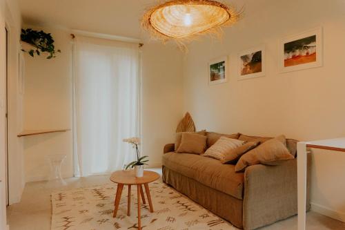 ein Wohnzimmer mit einem Sofa und einem Tisch in der Unterkunft Studio Palmito in Bidart