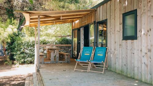 dos sillas azules sentadas en el porche de una casa en Camping La Prée en Les Portes