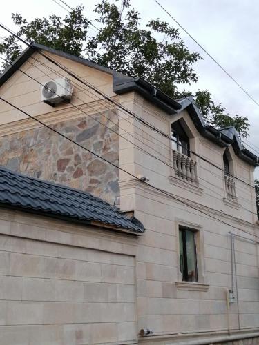 a stone building with a window and a balcony at Viva hotel Gabala with outdoor pool ,Sauna and Waterfall in Gabala