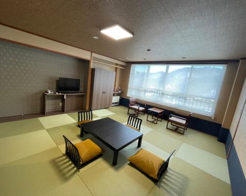 a room with a table and chairs and a window at Kouunsou in Nasushiobara