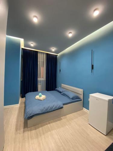 a bedroom with a bed and a blue wall at Aylin apartments 359/3 in Almaty