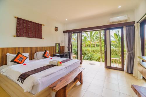 Un pat sau paturi într-o cameră la Adhidrawa Ubud