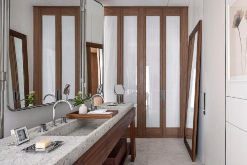 a bathroom with a sink and a large mirror at R48 Hotel and Garden in Tel Aviv