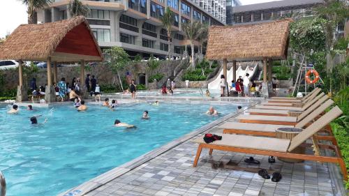 a group of people swimming in a swimming pool at Apec mandala Mũi Né in Ấp Khánh Phước (1)
