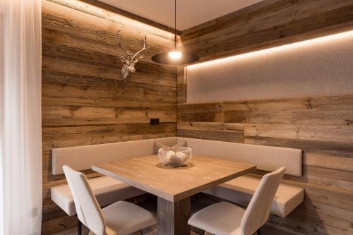 a dining room with a wooden wall with a table and chairs at Obergasserhof Apt Gipfelstürmer in Riscone