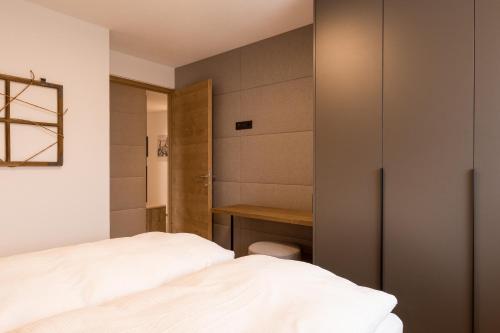 a bedroom with a bed and a desk at Obergasserhof Apt Gipfelstürmer in Riscone