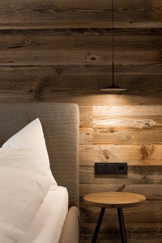 a bedroom with a bed and a table and a lamp at Obergasserhof Apt Waldruhe in Riscone