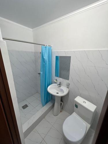 a white bathroom with a toilet and a sink at Гостиница Набережная in Balqash