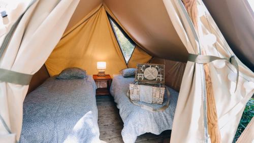 a room with two beds in a tent at Camping La Prée in Les Portes